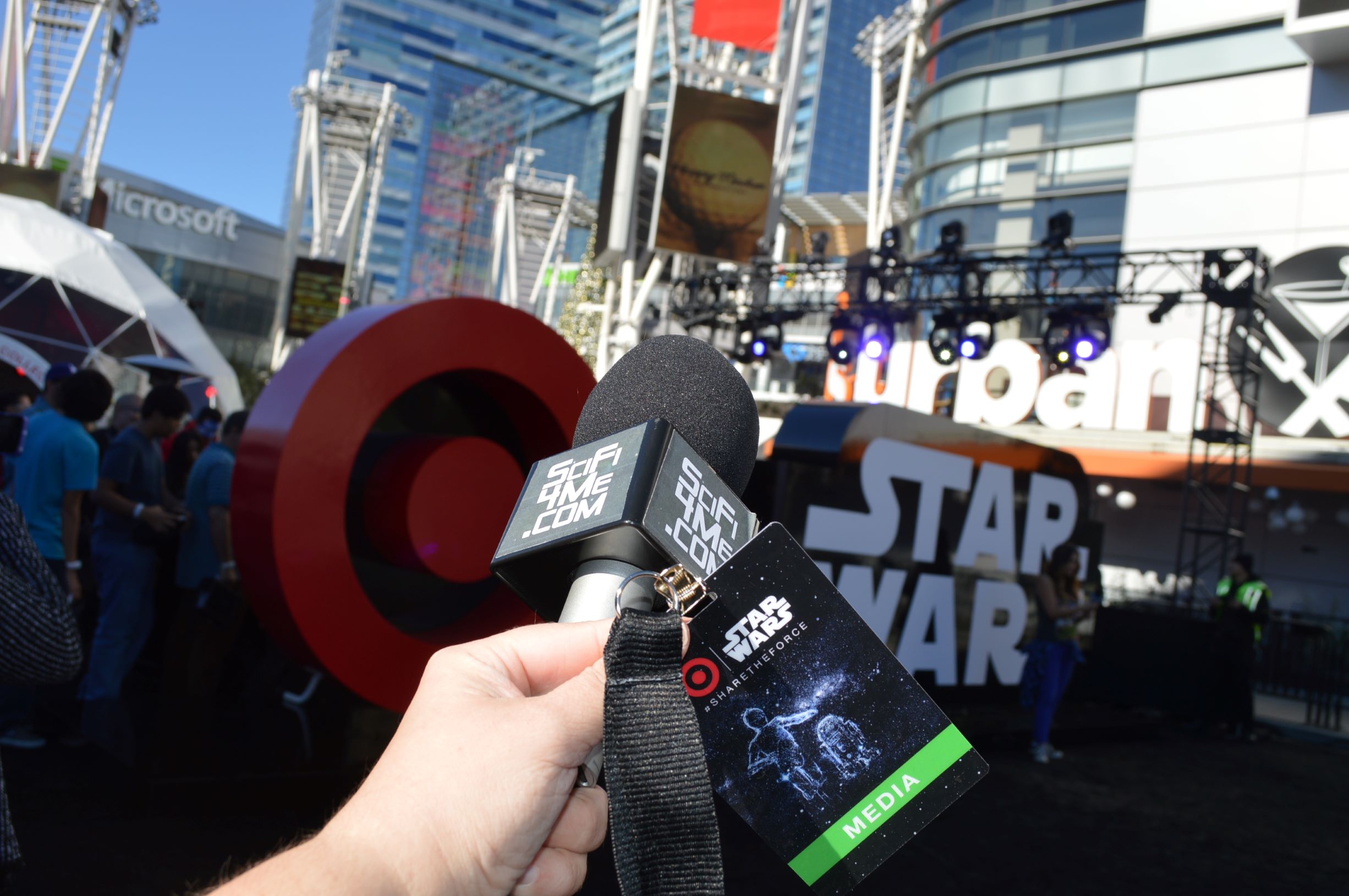 a microphone with a media badge in front of a sign with the Target logo and the Star Wars logo